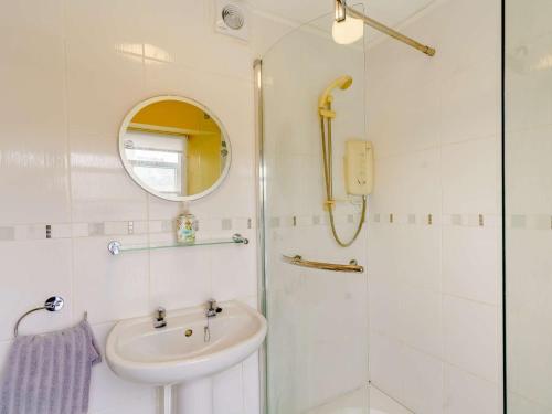 a bathroom with a shower and a sink and a mirror at 1 Bed in Tenby 83320 in Tenby