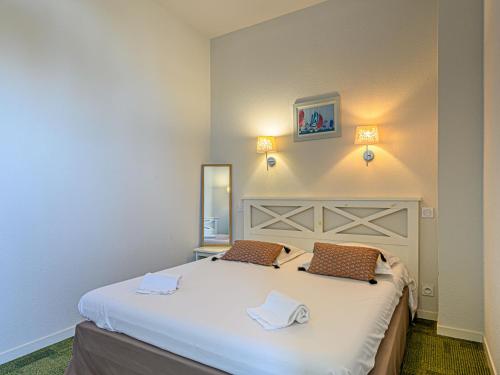 une chambre avec un grand lit blanc avec deux oreillers dans l'établissement Apartment Château De Kergonano-12 by Interhome, à Baden