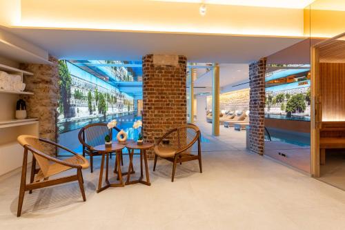 uma sala de jantar com um pilar de tijolo e uma mesa e cadeiras em Hotel Astra Opera - Astotel em Paris