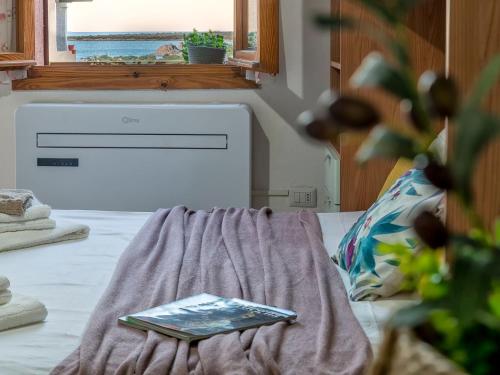 a book sitting on top of a bed with a window at Apartment 0-5-N - Marineledda by Interhome in Golfo Aranci