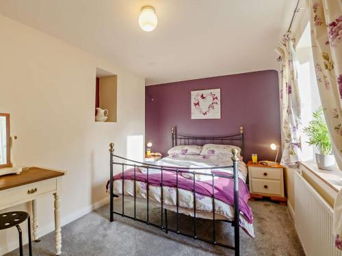 a bedroom with a bed and a purple wall at 2 Bed in Betws y coed 80629 in Gwytherin