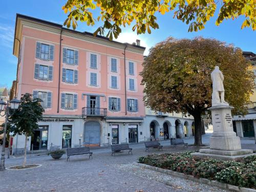 a statue in front of a pink building at Apartment La Terrazza sul Borgo by Interhome in Bellano