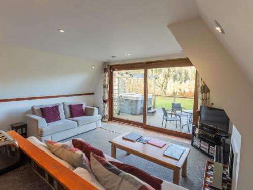 a living room with a couch and a table at Chalet Lodge 4 by Interhome in Spean Bridge