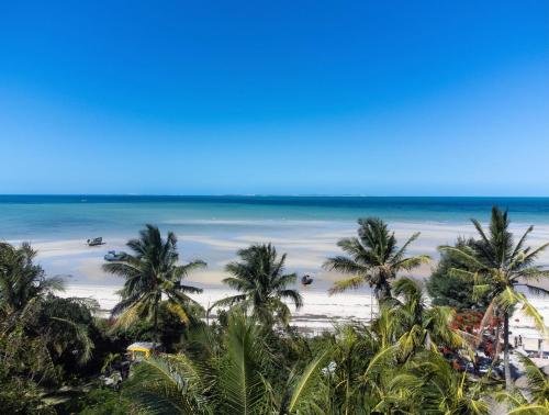 vistas a una playa con palmeras y al océano en Samara Lodge, en Vilanculos