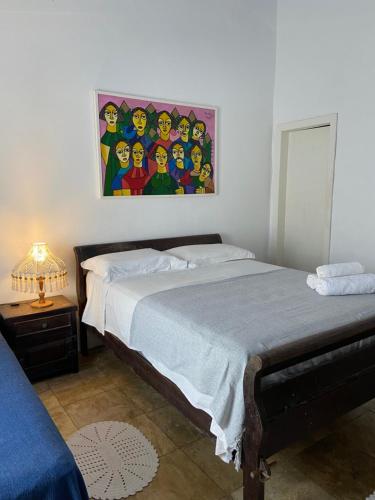 a bedroom with a bed with a painting on the wall at Peixe Crew Manguinhos in Búzios