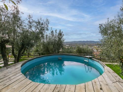 une grande piscine bleue sur une terrasse en bois avec des arbres dans l'établissement Holiday Home by Interhome, à Sesto Fiorentino