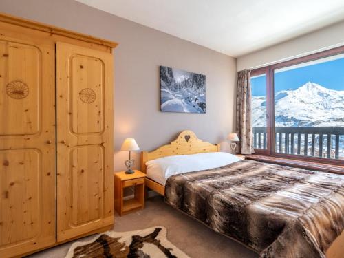 - une chambre avec un lit et une fenêtre avec des montagnes enneigées dans l'établissement Apartment Le Bec Rouge - Le Lac-10 by Interhome, à Tignes