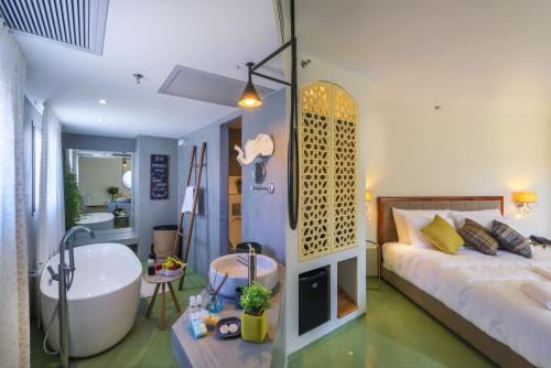 a bedroom with a tub and a bed and a bathroom at Margosa Boutique Hotel Tel-Aviv Jaffa in Tel Aviv