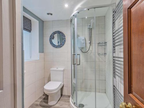 a bathroom with a toilet and a glass shower at 5 Bed in Thorpe 85565 in Thorpe