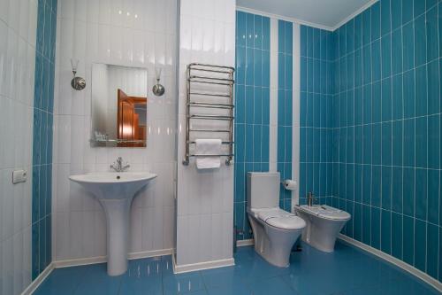ein Badezimmer mit einem Waschbecken, einem WC und einem Waschbecken in der Unterkunft Cherkasy Palace in Tscherkassy