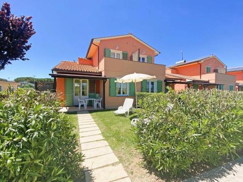 a house with a patio and an umbrella at Apartment Grecale by Interhome in Mazzanta