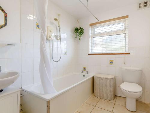 a bathroom with a tub and a toilet and a sink at 2 bed property in Wadebridge 87231 in Egloshayle