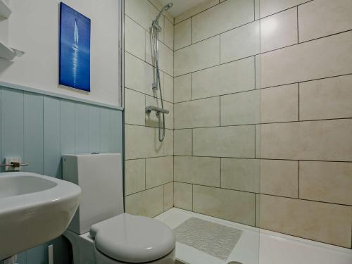 La salle de bains est pourvue d'un lavabo, de toilettes et d'une douche. dans l'établissement 4 Bed in Aberdovey 86911, à Aberdyfi