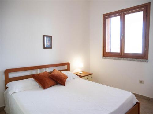 1 dormitorio con 1 cama con sábanas blancas y ventana en Apartment Tanca Torre 60P by Interhome, en Trinità dʼAgultu