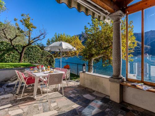 een tafel en stoelen op een patio met uitzicht op het water bij Holiday Home La Spiaggetta by Interhome in Cima