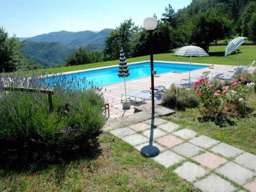 a swimming pool with a light pole in a garden at Holiday Home Al Volo del Nibbio by Interhome in Marradi