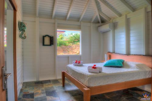 ein Schlafzimmer mit einem Bett in einem Zimmer mit einem Fenster in der Unterkunft Le Domaine de l'Ilet in Saint-Claude