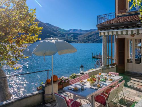 a table with an umbrella on a patio with a view of a lake at Holiday Home La Spiaggetta by Interhome in Cima