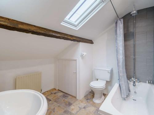 a bathroom with a toilet and a tub and a sink at 4 Bed in Keswick 86250 in Threlkeld