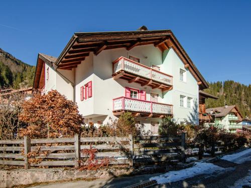 a house in the mountains with red windows and a fence at Apartment Casa Bucci by Interhome in Campestrin