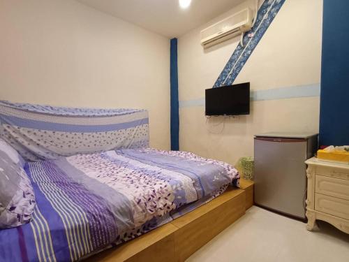 1 dormitorio con 1 cama y TV de pantalla plana en Fengjia Line Stack, en Taichung