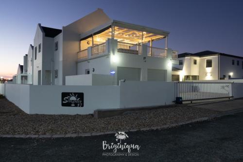 a large white house with a fence in front of it at SHB Sonvanger in St Helena Bay