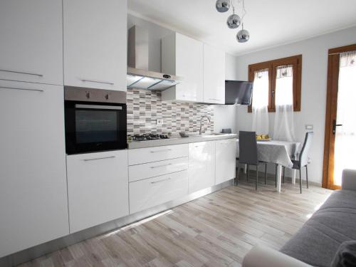 a white kitchen with white cabinets and a table at Apartment Bilo Satta by Interhome in Trinità d'Agultu e Vignola