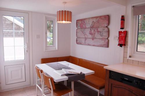 una cocina con una mesa y sillas blancas y una ventana en Hafan Y Talgarth bungalow at Plas Talgarth resort, en Pennal