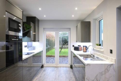 a kitchen with a sink and a large window at Exclusive 8beds 2bath Luxury Contractors Delight! in Southampton