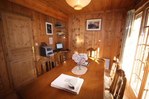une table de salle à manger avec un vase de fleurs dessus dans l'établissement Chamonix Chalets, aux Houches