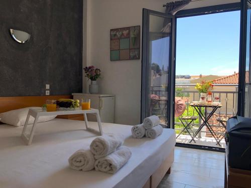 Zimmer mit Handtüchern auf einem Bett und einem Balkon in der Unterkunft Central Guest House Skiathos in Skiathos-Stadt