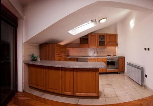 uma grande cozinha com armários de madeira e uma bancada em 3 Bedroom Ana's Rest Apartment by the sea em Kaštela