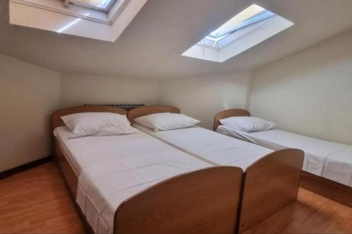 duas camas num quarto com duas clarabóias em 3 Bedroom Ana's Rest Apartment by the sea em Kaštela