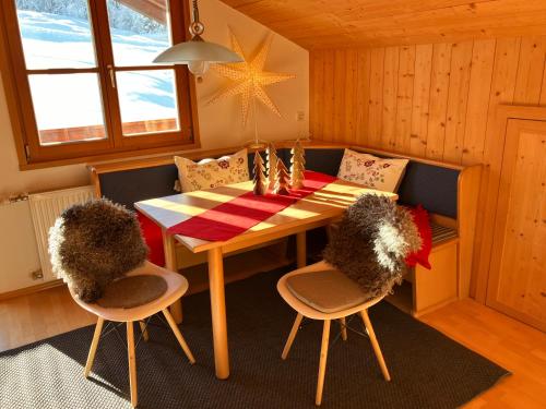 a dining room with a table and two chairs at Ferienwohnung Bergblick am Rande der Wildnis in Sibratsgfäll