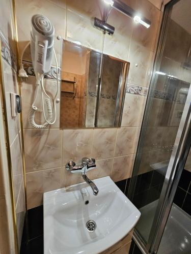 a bathroom with a sink and a hair dryer on the wall at Villa Krystyna in Dźwirzyno