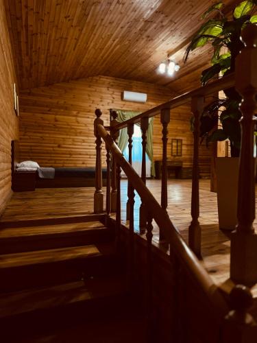 a staircase in a building with a wooden ceiling at Райский Дворик in Pogreby