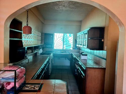 a kitchen with an archway in the middle of it at The Seaside Garden Guesthouse in Buccoo