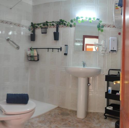 a bathroom with a sink and a toilet and a mirror at Yaramar in Órzola