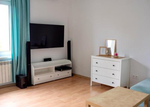 a living room with a tv and a white dresser at Domek Wilgówka in Jastrzębia