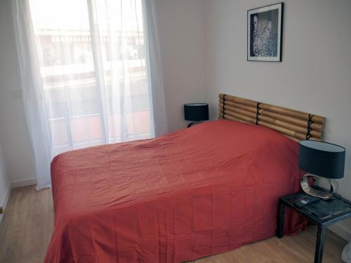 a bedroom with a red bed and a window at Le Penthouse des Halles in Perpignan