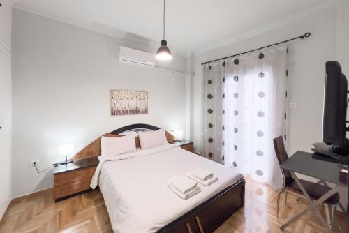 a bedroom with a large bed and a television at Cozy Cityscape Apartment in Athens in Athens