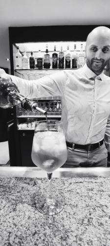 a man standing behind a counter with a wine glass at Hotel Everest Arco in Arco