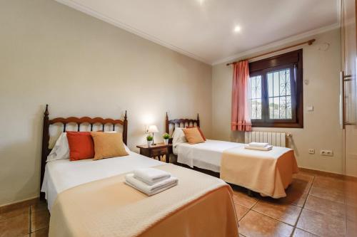 1 dormitorio con 2 camas y ventana en Villas Guzman - Fina, en Moraira