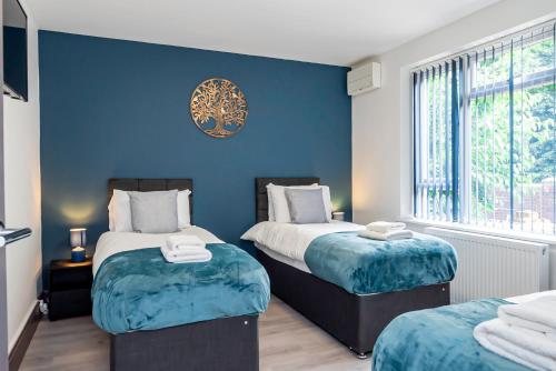 two beds in a room with blue walls at Executive 8beds 3bath Contractors Welcome Parking in Southampton