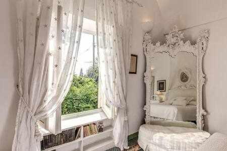 カプリにあるGreen Coral Villa di lusso 1950のベッドルーム1室(ベッド1台、鏡、窓付)