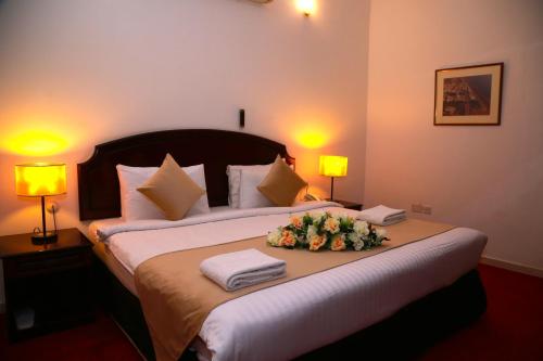 a bedroom with a large bed with flowers on it at Ibri Oasis Hotel in Ibri