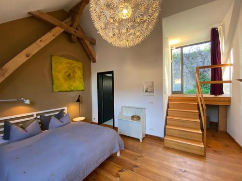 um quarto com uma cama grande e um lustre em Gasthof zum grünen Baum em Boitzenburg