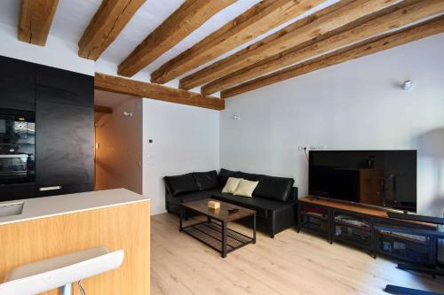 a living room with a black couch and a tv at Apartamento Chapitela Deluxe in Pamplona