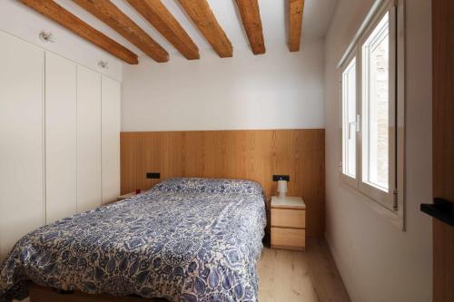 a bedroom with a bed with a blue comforter at Apartamento Chapitela Deluxe in Pamplona