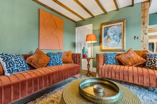 a living room with two couches and a table at Marsh Mallow Cottage - Hot Tub Packages Available in Loughborough